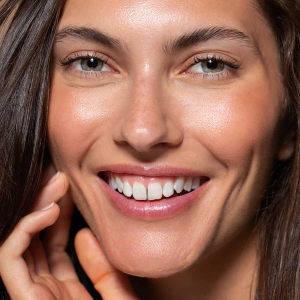 six gldn model smiling with glowing skin and rosy cheeks